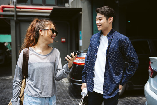 一对年轻的亚洲夫妇在城里散步聊天。
