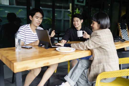 一群年轻的亚洲商人在咖啡馆策划项目。