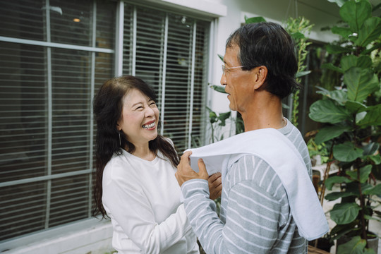 亚洲老夫妇一起在家运动训练后用毛巾清洁身体。