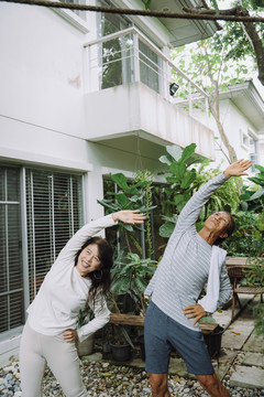 健康的亚洲老夫妇在家一起做健身健美操。