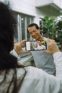 亚洲资深夫妇在家用智能手机拍照。