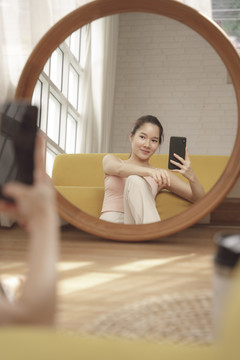 年轻的亚洲美女在家锻炼后为自己拍照。