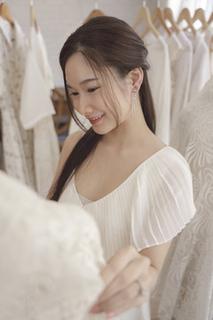 亚洲新娘选择婚礼礼服的美丽肖像。