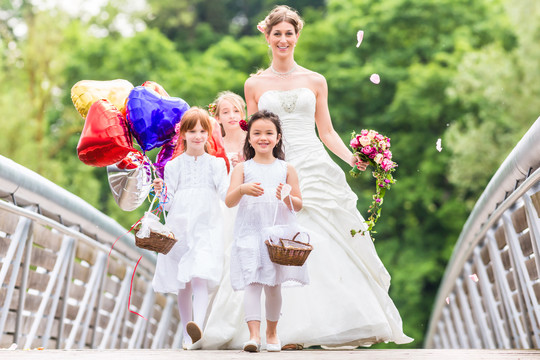 穿着白色礼服和花篮的带花儿的新娘或伴娘