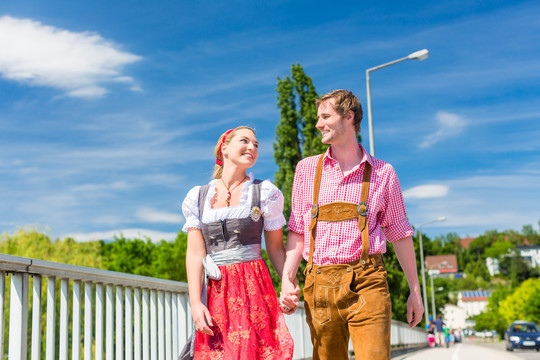 这对夫妇穿着民族服装皮裤和迪恩德尔一起参观巴伐利亚博览会