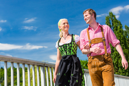 这对夫妇穿着民族服装皮裤和迪恩德尔一起参观巴伐利亚博览会