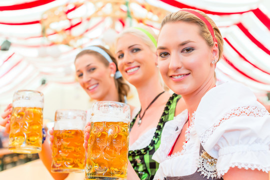 朋友们穿着民族服装一起喝巴伐利亚啤酒或在啤酒节上喝迪恩德啤酒