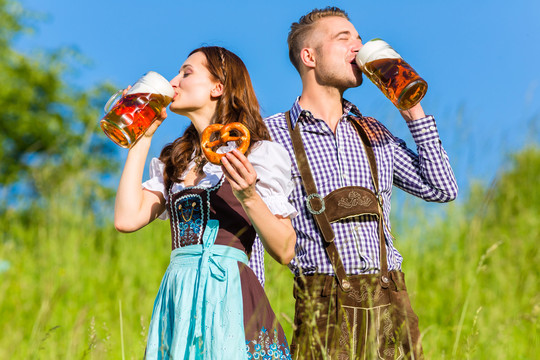 一对德国夫妇喝着啤酒和椒盐卷饼