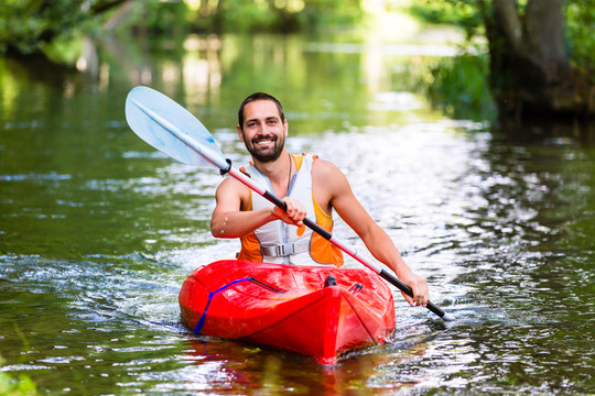 男子在森林河上驾驶皮划艇