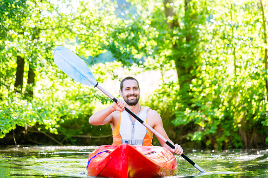 男子在河上划皮艇进行水上运动