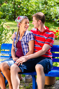 花园里的男人和女人坐在长凳上