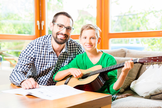 父子俩在家弹吉他，一起作曲