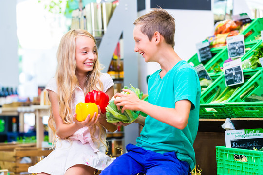 孩子们在超市买有机食品时选择蔬菜