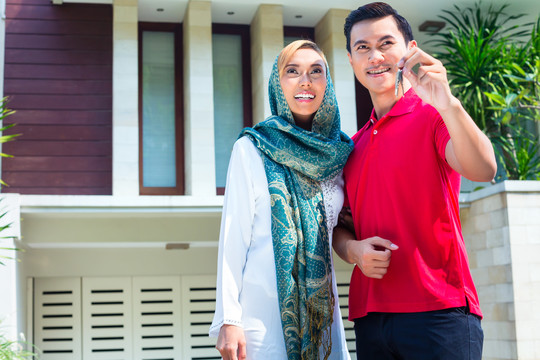 亚洲穆斯林男女拿着钥匙搬进房子