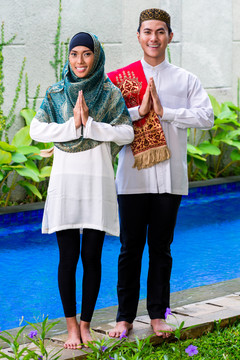 亚洲穆斯林男女穿着传统服装迎接客人