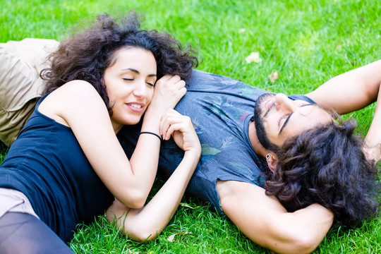 一对拉丁男女，女朋友和男朋友，夏天在草地上睡觉