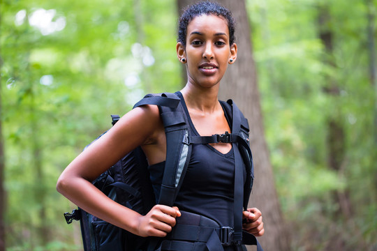 非洲年轻女子在森林小道上徒步旅行