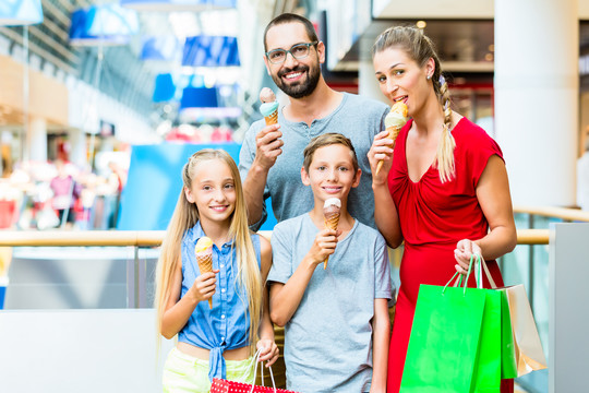 一家人在购物中心用袋子吃冰淇淋