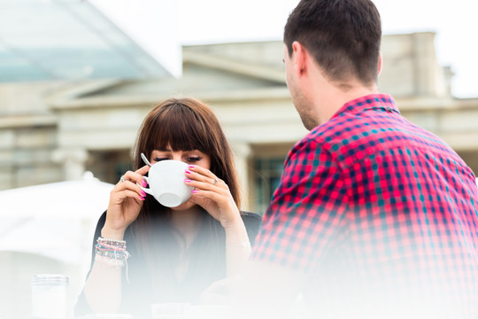 一个女人在户外咖啡馆和她的朋友喝咖啡的特写镜头