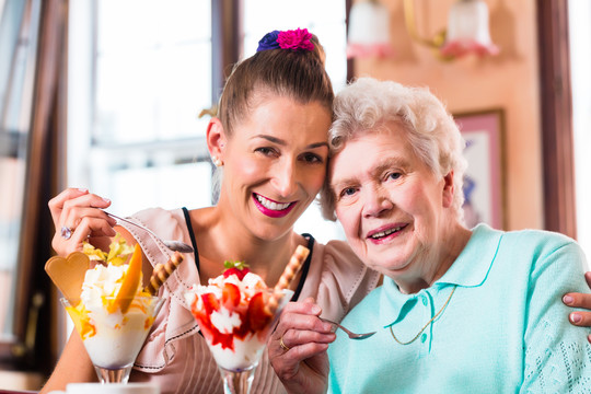 老太太和孙女在咖啡馆吃冰淇淋圣代