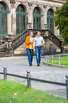 德累斯顿的一对旅游夫妇在茨温格边喝咖啡边散步