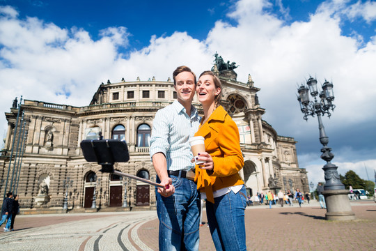 德累斯顿Semperoper的一对旅游情侣手持手机自拍