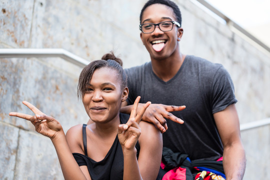一对年轻的非洲裔美国夫妇在户外摆姿势时做鬼脸的画像
