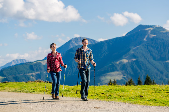 一对夫妇在高山上用阿尔卑斯全景进行北欧步行运动