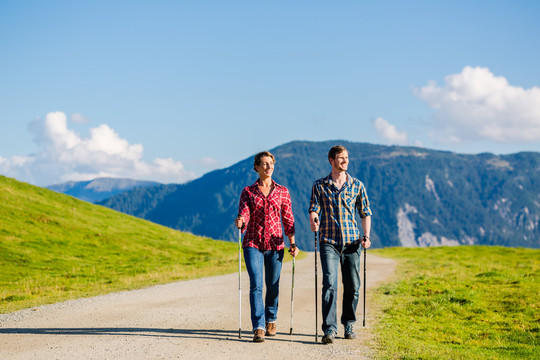 一对夫妇在高山上用阿尔卑斯全景进行北欧步行运动