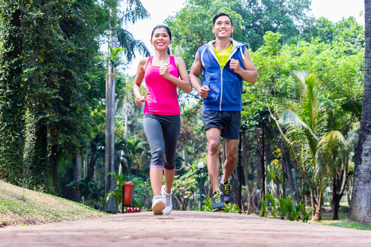 亚洲夫妇，男女，在热带亚洲公园慢跑或跑步健身