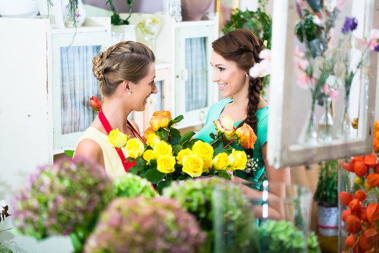 花店的女花商和顾客在讨论产品