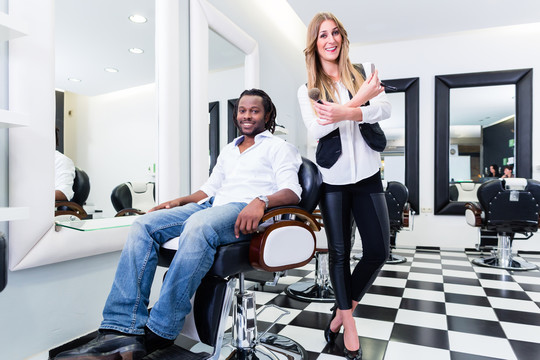 沙龙或商店理发师和客户、白人专业人士和非洲客户