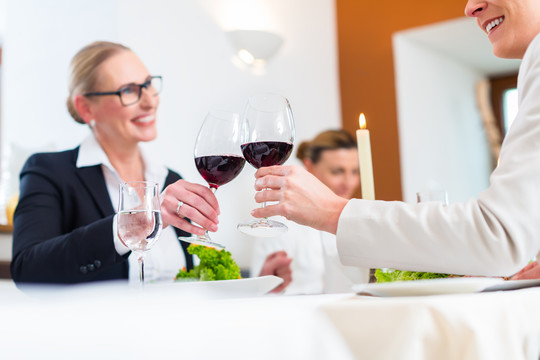 商务午餐上的妇女们用葡萄酒举杯庆祝一项协议