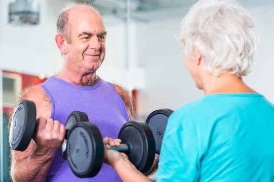老年夫妇，男男女女，在健身房举重哑铃进行健身锻炼