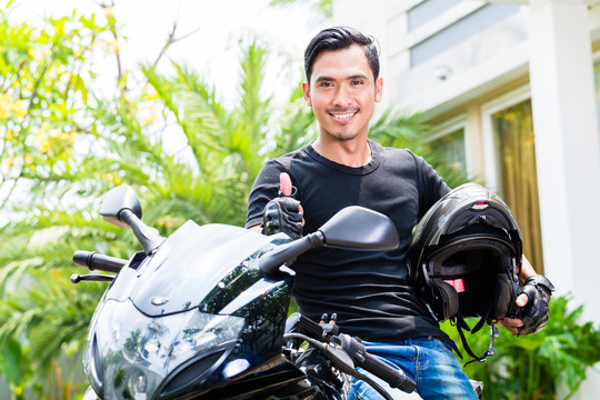 亚洲年轻人和他的摩托车或踏板车
