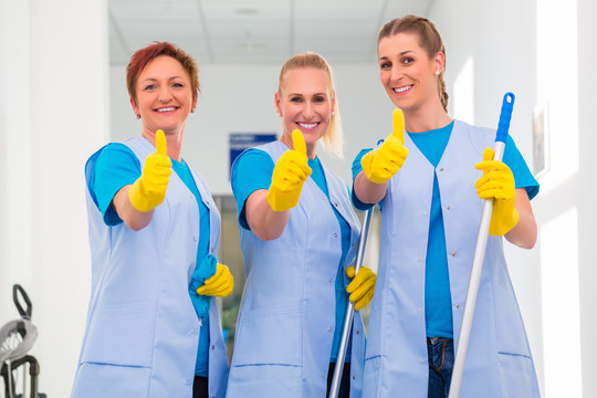 清洁女工在团队中展示竖起大拇指的标志