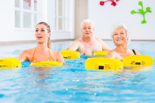 老年人和青年人在水上体操中使用阻力装置