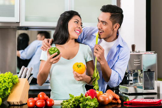 亚洲夫妇，男人和女人，一起在厨房做饭准备晚餐