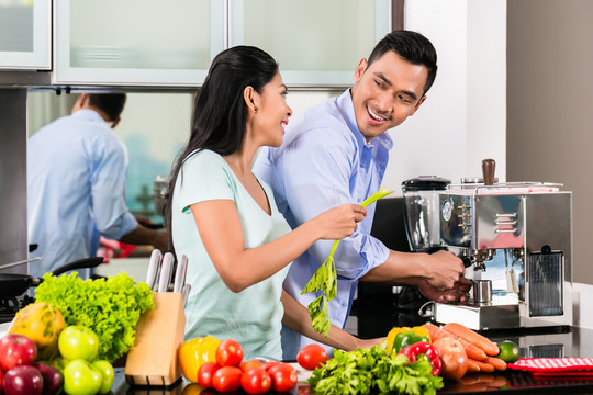 亚洲夫妇，男人和女人，一起在厨房做饭和煮咖啡