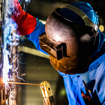 在制造钢设备的工业环境中工作的焊工
