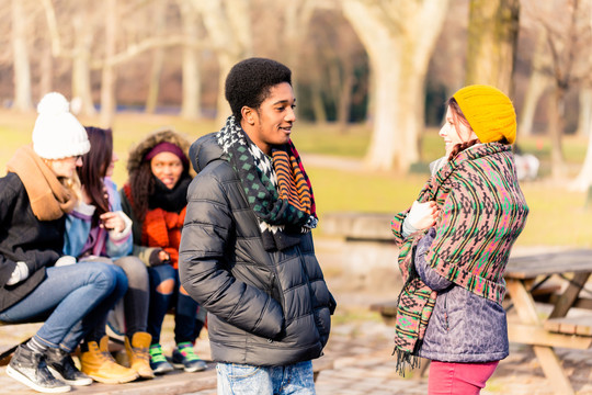 一位非洲裔美国年轻人在冬天的户外与一位女性朋友交谈