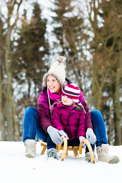 冬天雪橇上的女人和女儿