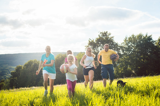 夏季景观中的家庭玩耍、跑步和运动