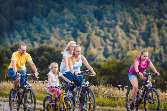 一家人下午在夏日的乡间骑自行车