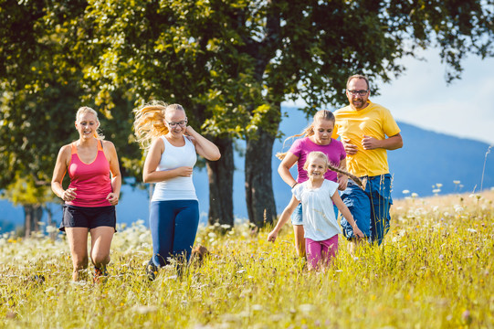 家人、母亲、父亲和孩子们在草地上跑步运动