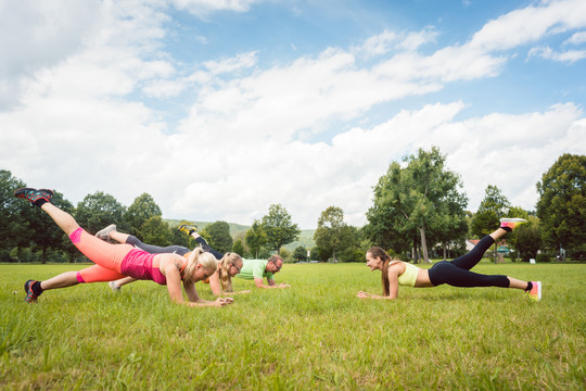 一家人在草地上户外铺板，健身老师享受户外生活方式
