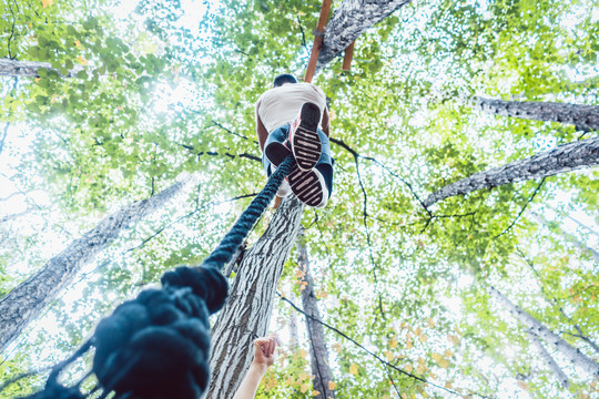 非常健康和运动型的男子在森林体育馆攀爬绳索