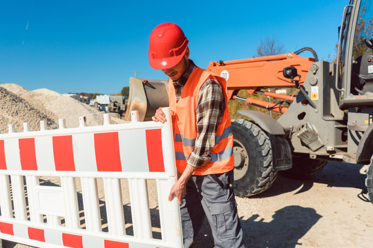 工人设置土方工程施工现场安装围栏