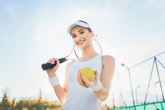 女子网球运动员在球场上展示球