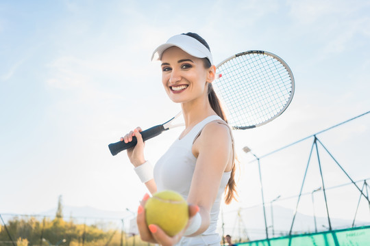 一个正在打网球的女人在展示球